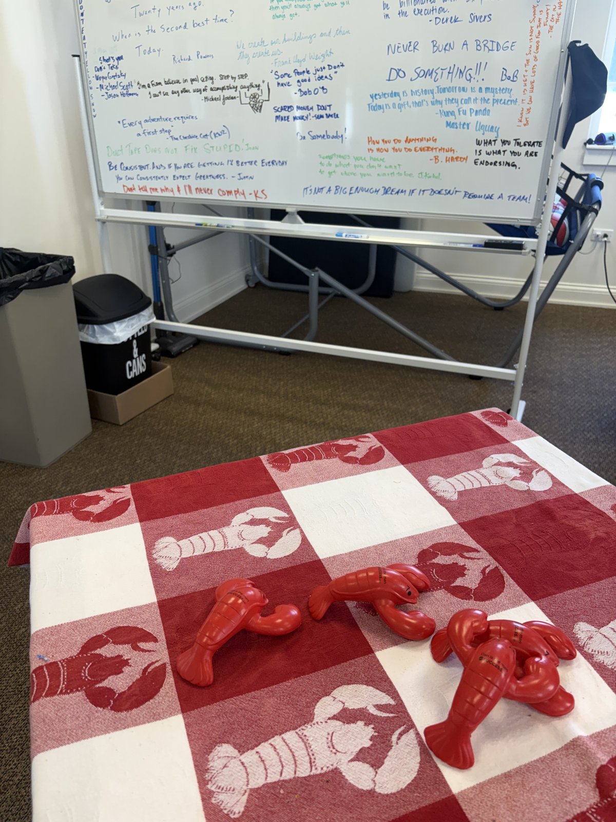 Whiteboard of quotes beside a lobster-print table in the session room